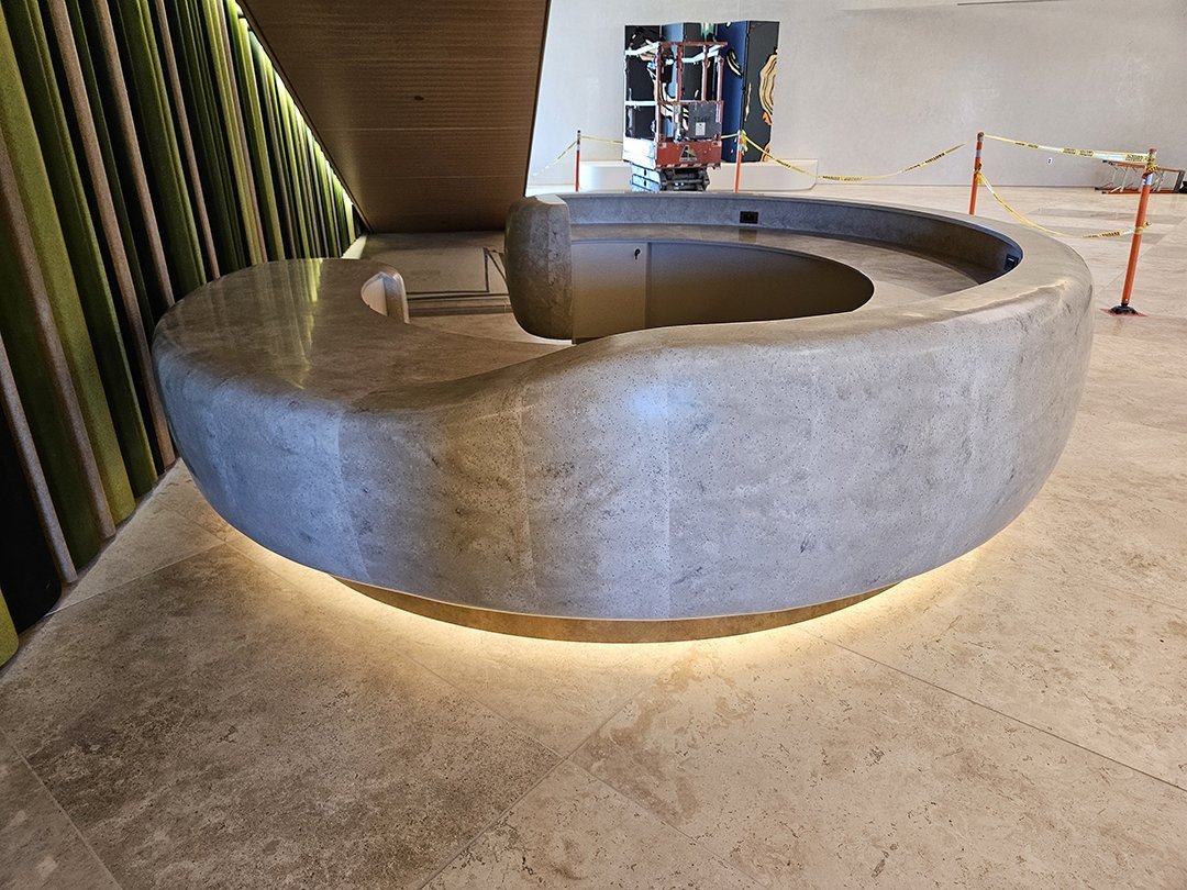 Reception desk — solid surface and brass toekick