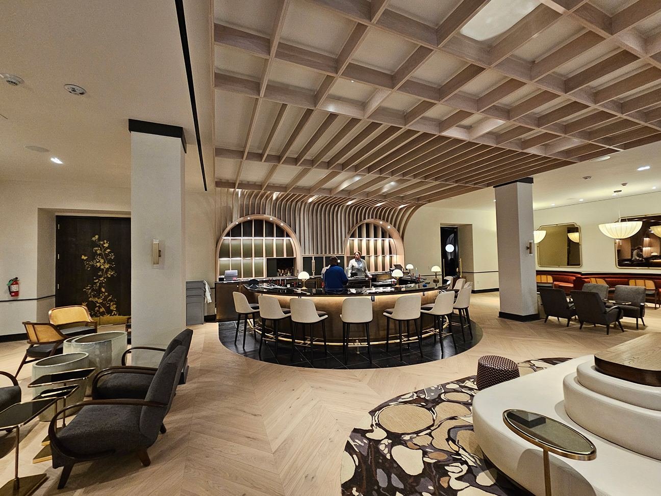 Lobby bar — curved brass-front bar, full view with seating